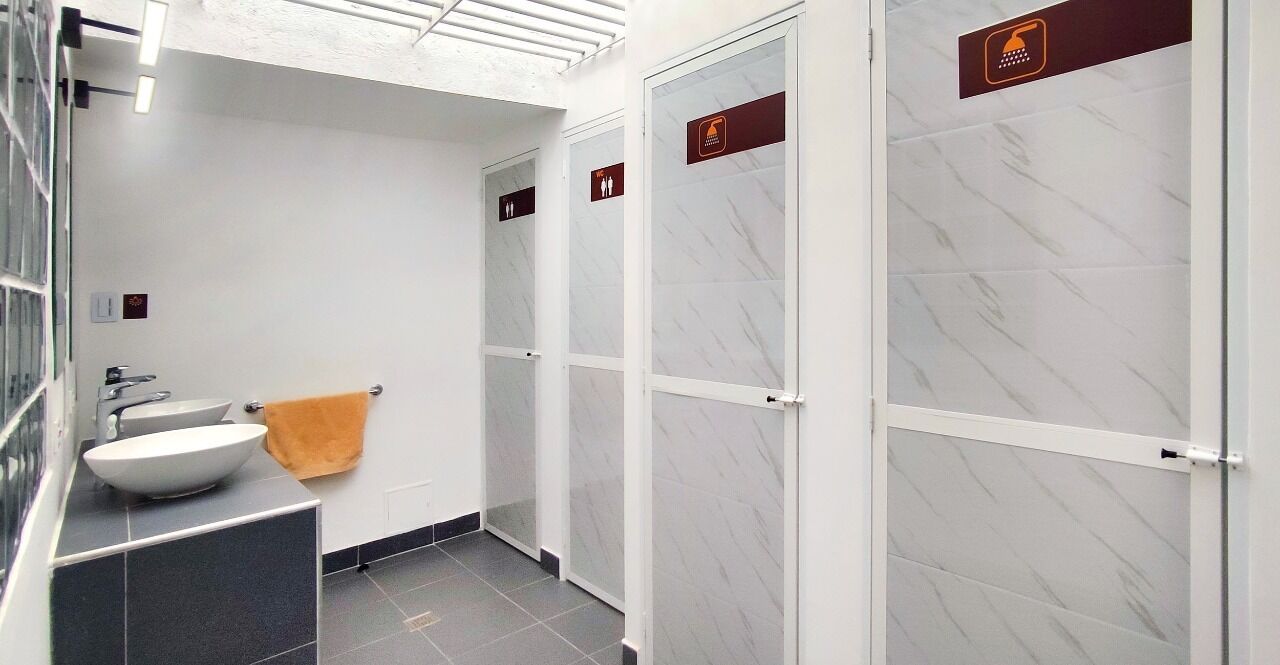A modern bathroom with a white sink, a towel, and glass-enclosed shower stalls.