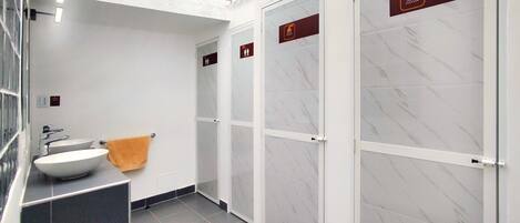 A modern bathroom with a white sink, a towel, and glass-enclosed shower stalls.