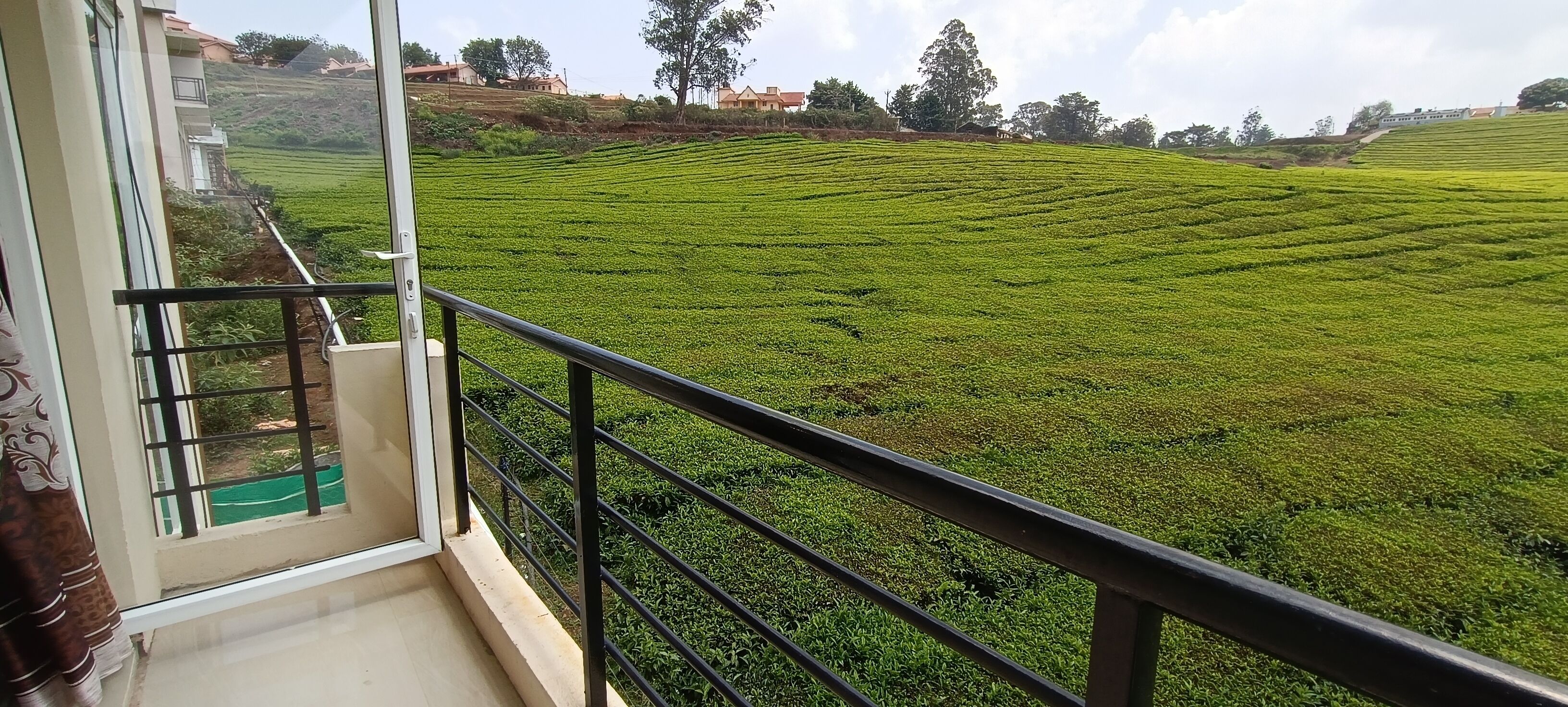 Un balcón con vista a una plantación de té verde.