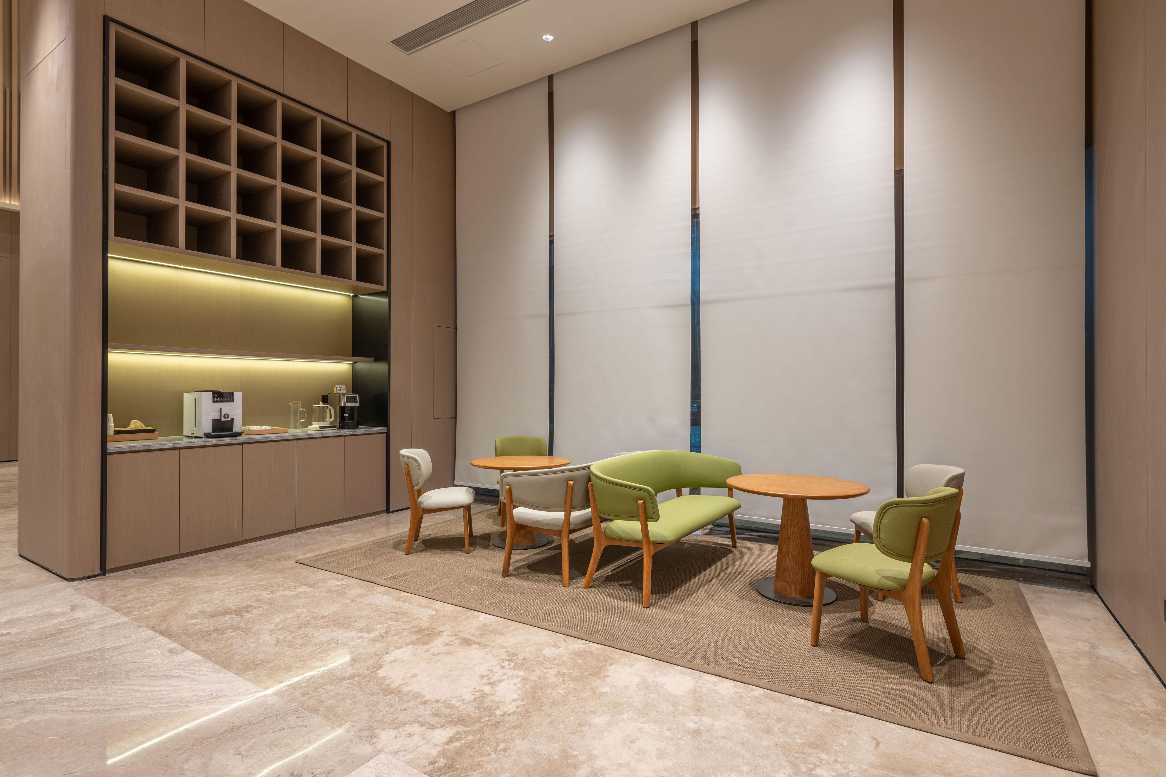 A modern interior with a kitchen area, seating arrangement, and a large wall with vertical lines.