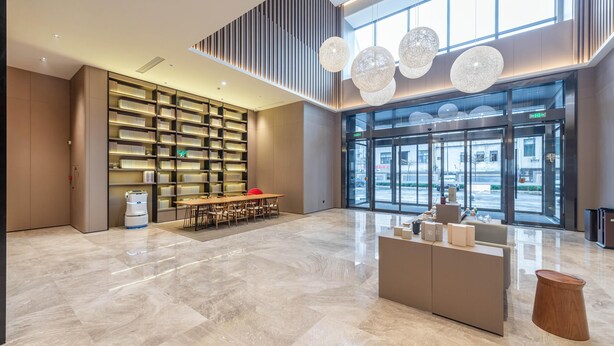 A spacious lobby with a high ceiling, a large seating area, a reception desk, and a large window offering a view of the street. - Ji Hotel Guangzhou Xintang South Station (Guangzhou)