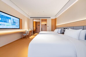 Une chambre d’hôtel avec un grand lit, un bureau avec une chaise, un écran de télévision et une porte donnant sur une autre pièce.