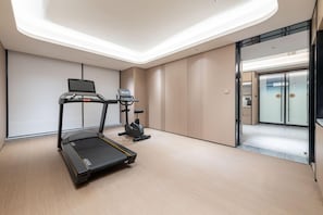 A modern fitness room with a treadmill, elliptical, and stationary bike. - Ji Hotel Guangzhou Xintang South Station (Guangzhou)