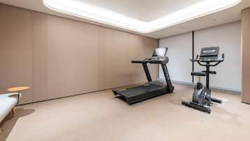 A modern fitness room with a treadmill and an elliptical machine.