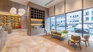 A modern interior with a kitchen area, seating, and large windows offering a view of the street. - Ji Hotel Guangzhou Xintang South Station (Guangzhou)