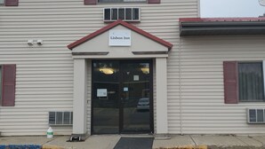 A Lisbon Inn building with a sign above the entrance, a garage door, and a satellite dish on the roof.