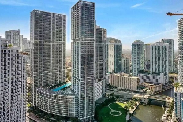 Un complejo residencial de edificios altos con múltiples torres, un patio central y una fuente de agua.