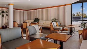 Een modern interieur met zitplaatsen, houten tafels en potplanten.