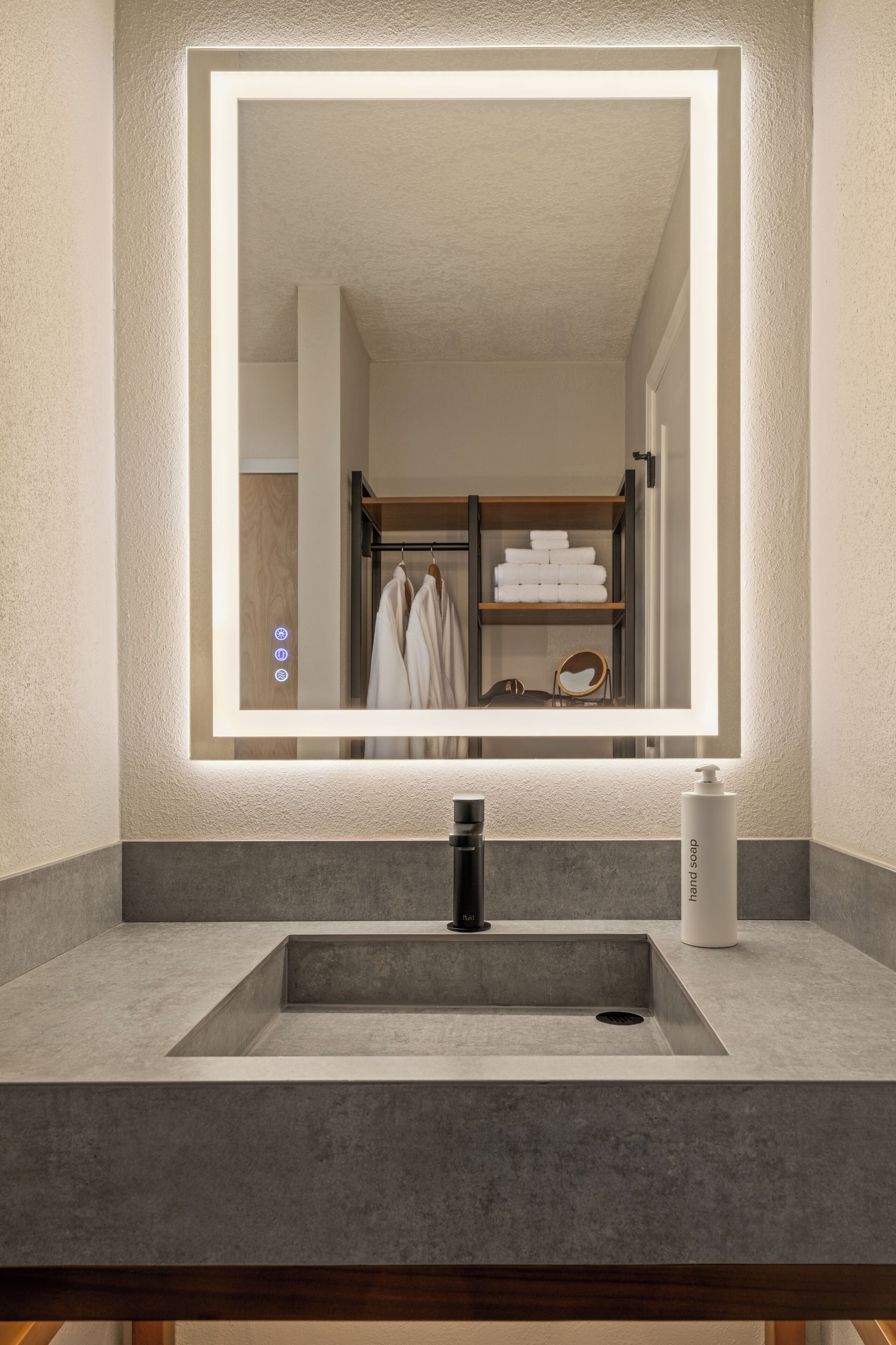 A bathroom with a large mirror, a modern sink, and a towel rack.