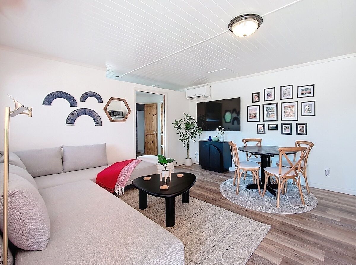 A modern living room with a sofa, coffee table, and dining area.