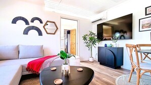 Ein modernes Wohnzimmer mit einer Couch, einem Couchtisch und einem Essbereich mit Stuhl und Tisch.