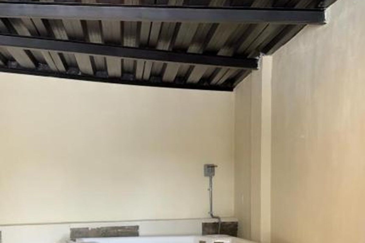 Un espace de bien-être comprenant une baignoire en bois, un banc et un luminaire au plafond.