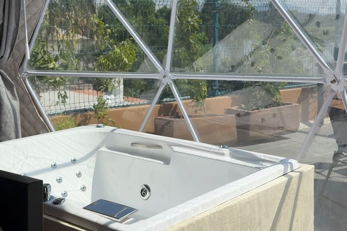 Une salle de bain moderne avec une baignoire sur pieds, de grandes fenêtres et une vue sur l’extérieur.