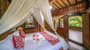 A room with a bed, canopy, wooden walls, and windows. - Yoga Maya Villa (Bali)