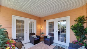 A covered porch with two wicker chairs, a small table, and a potted plant. - 5 Mi to WDW: Resort-Style Condo w/ Pool Access (Kissimmee)