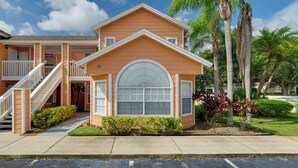 A two-story house with a front porch, a staircase, and a large arched window. - 5 Mi to WDW: Resort-Style Condo w/ Pool Access (Kissimmee)