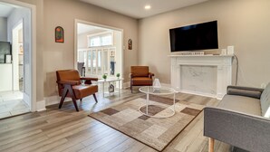A modern living room with a fireplace, a flat-screen TV, and a cozy seating area. - 3 Mi to Dtwn Detroit: Spacious Home w/ Yard! (Detroit)