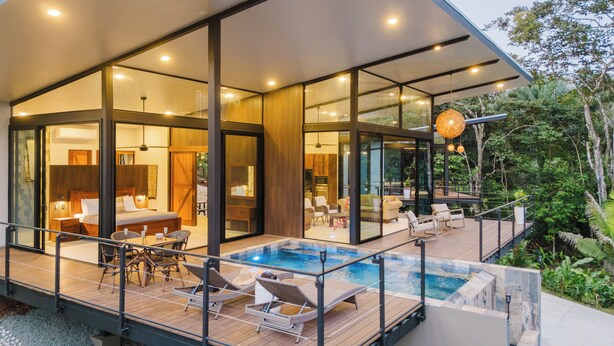 A modern house with a glass-enclosed living area, a pool, and outdoor furniture. - Wonderful 2-bedroom house with AC and private pool in Quepos (Quepos)