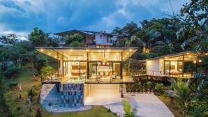 A modern house with a glass facade, a pool, and a well-maintained garden. - Wonderful 2-bedroom house with AC and private pool in Quepos (Quepos)