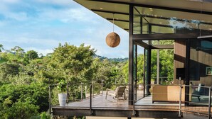 A modern building with a glass facade, a wooden deck, and outdoor seating. - Wonderful 2-bedroom house with AC and private pool in Quepos (Quepos)