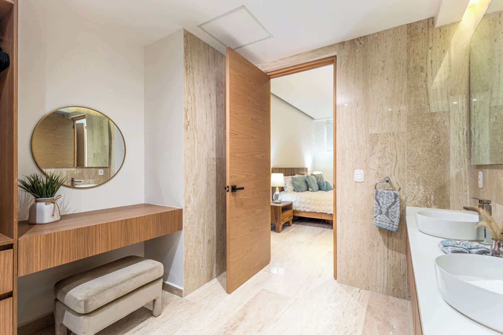 Une salle de bain moderne avec un meuble-lavabo en bois, un miroir rond et un lavabo blanc.