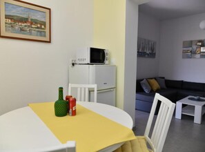 A compact living space with a dining area, a kitchenette, and a seating area. - Apartments Near Sea Supetar (Supetar)