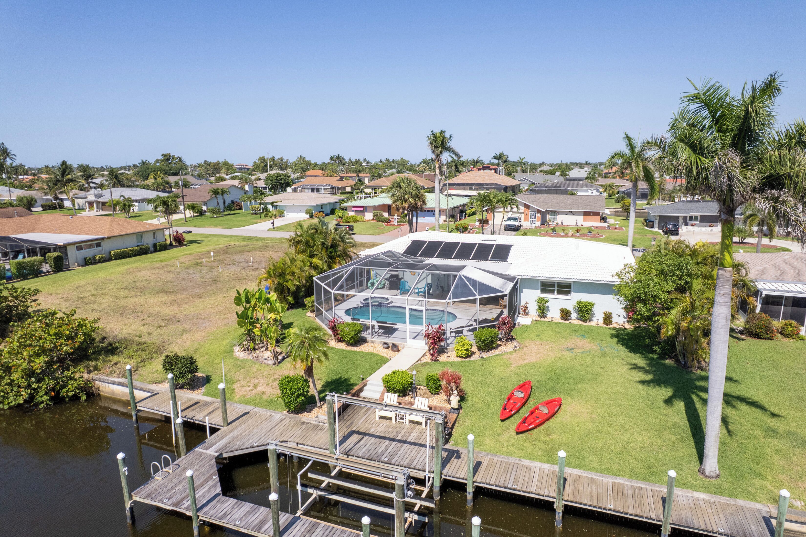 A residential property with a swimming pool, a dock, and a well-maintained lawn.