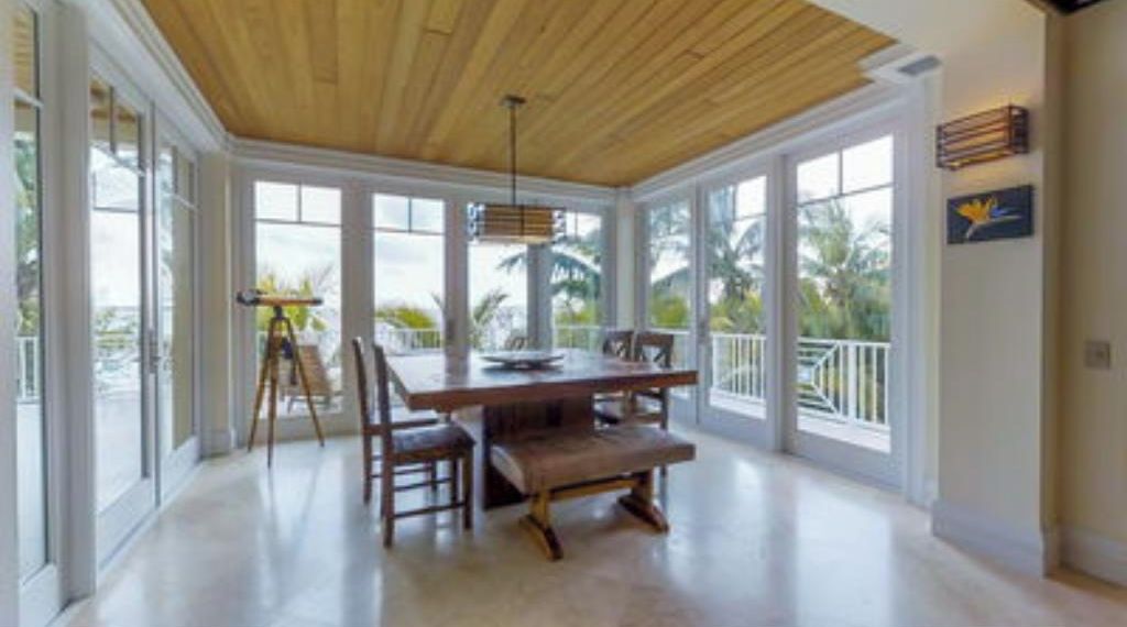 A spacious room with a large wooden table, multiple chairs, and a bench.