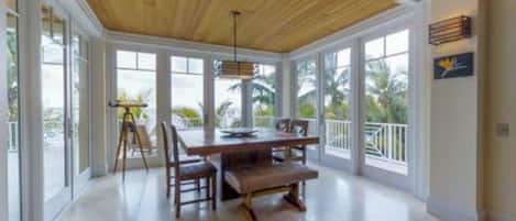 A spacious room with a large wooden table, multiple chairs, and a bench.