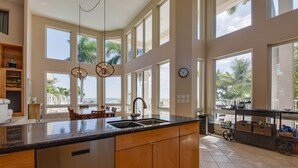 Una cocina amplia con una isla grande, varias ventanas y vistas a la playa.