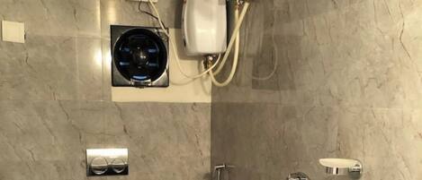A bathroom with a marble wall, a built-in heater, a handheld showerhead, a toilet paper holder, and a soap dish.