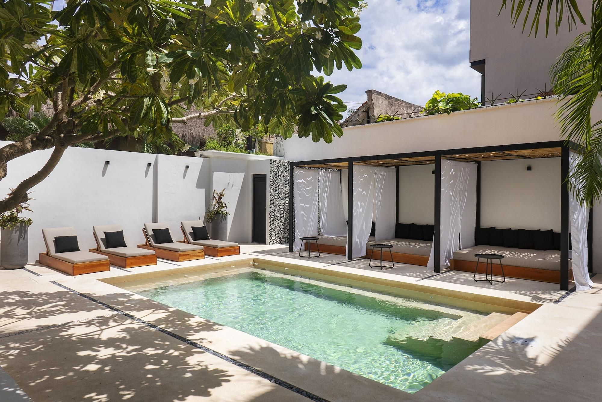 A poolside area with lounge chairs and a covered seating area.