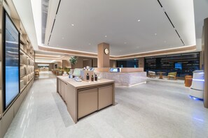 A modern hotel lobby with a reception desk, seating area, and a large digital display. - Ji Hotel Guangzhou Caihongqiao Metro Station (Guangzhou)