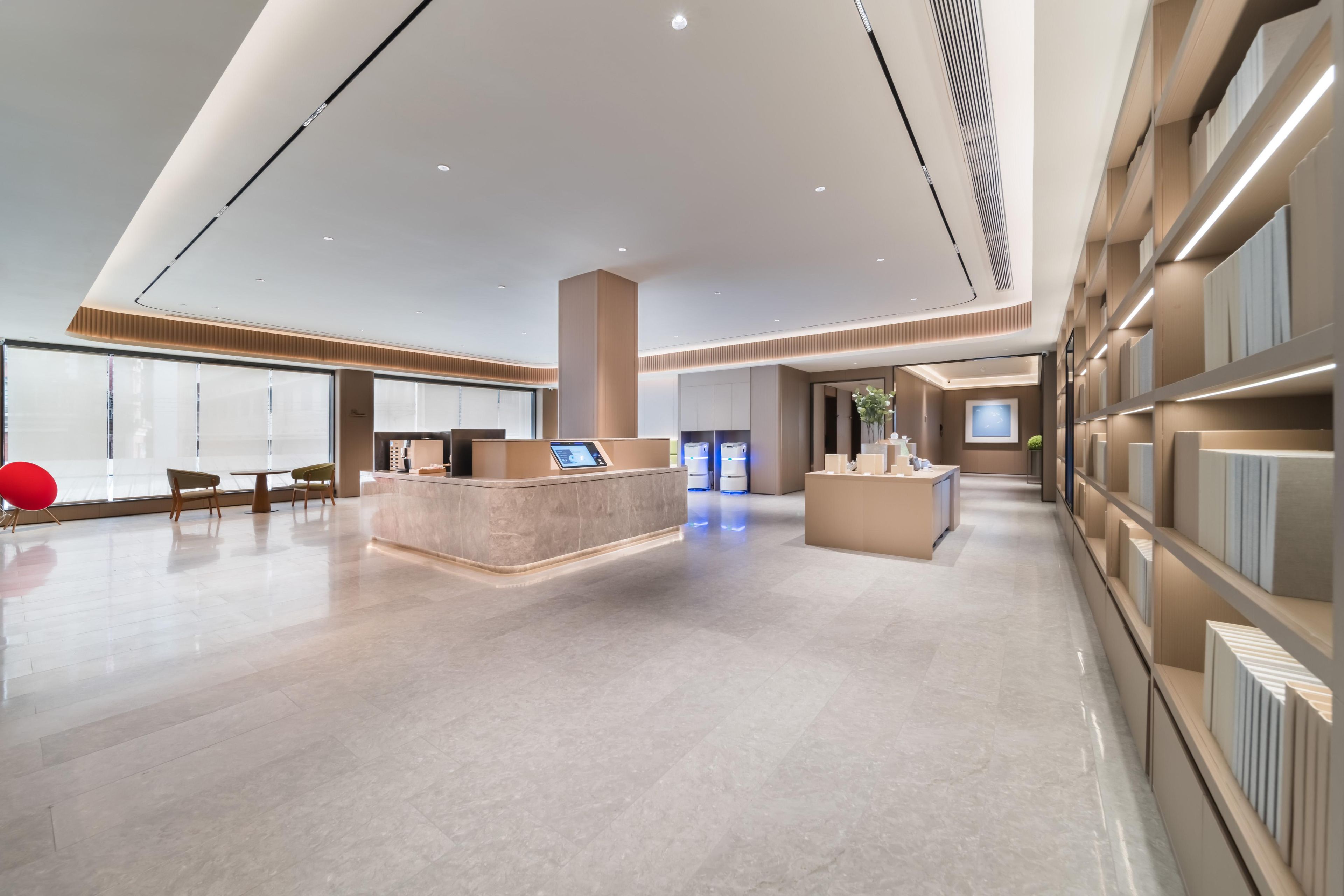 A spacious lobby with a reception desk, seating area, and a display of products.