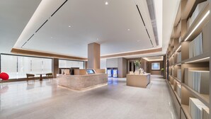 A spacious lobby with a reception desk, seating area, and a display of products.