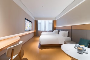A modern hotel room with a large bed, a desk, and a seating area. - Ji Hotel Guangzhou Caihongqiao Metro Station (Guangzhou)