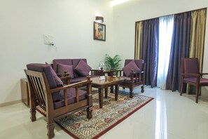 A living room with a sofa, armchairs, a coffee table, and a patterned rug. - The Orchid Hotel, Pune (Pune)