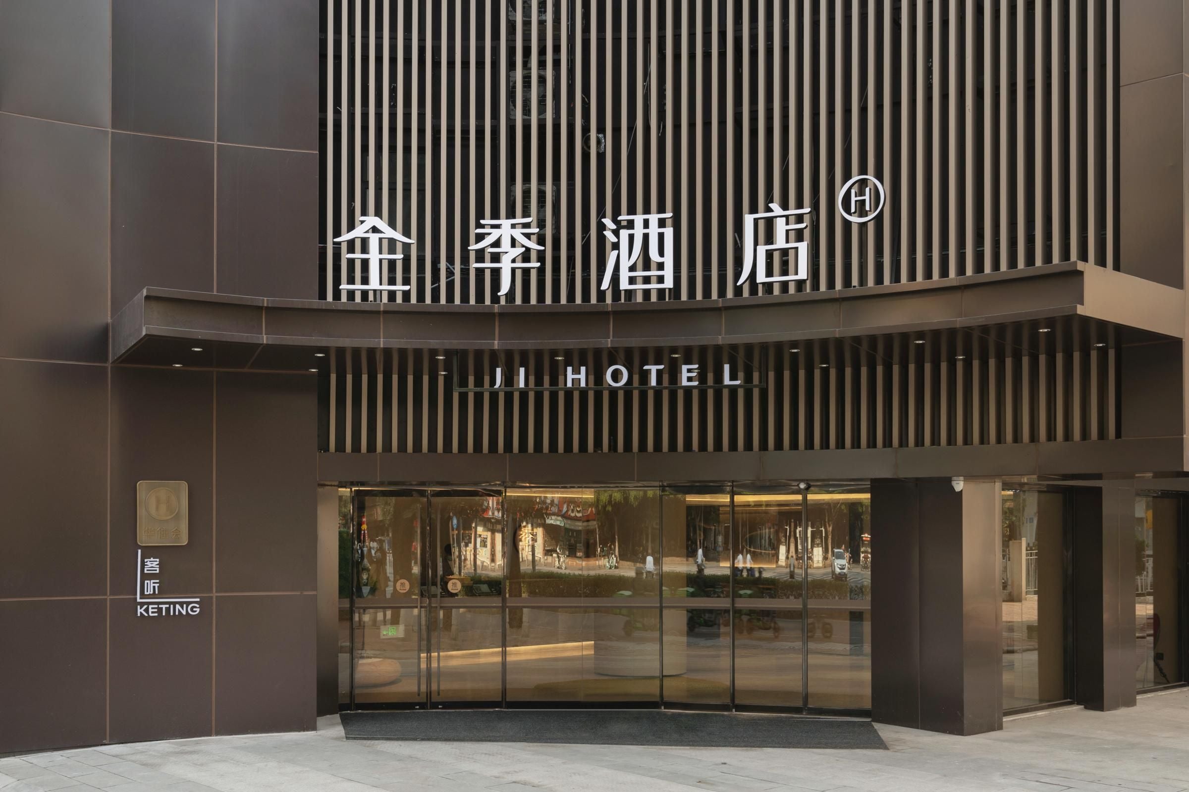 A modern hotel entrance with a prominent sign in Chinese characters and the word "HOTEL" in English.