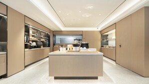 Une cuisine moderne dotée d’un îlot central, d’appareils électroménagers intégrés et de nombreux espaces de rangement.