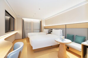 A modern hotel room with a large bed, a desk, a chair, and a sofa. - Ji Hotel Guangzhou Jiangtai Road Metro Station (Guangzhou)
