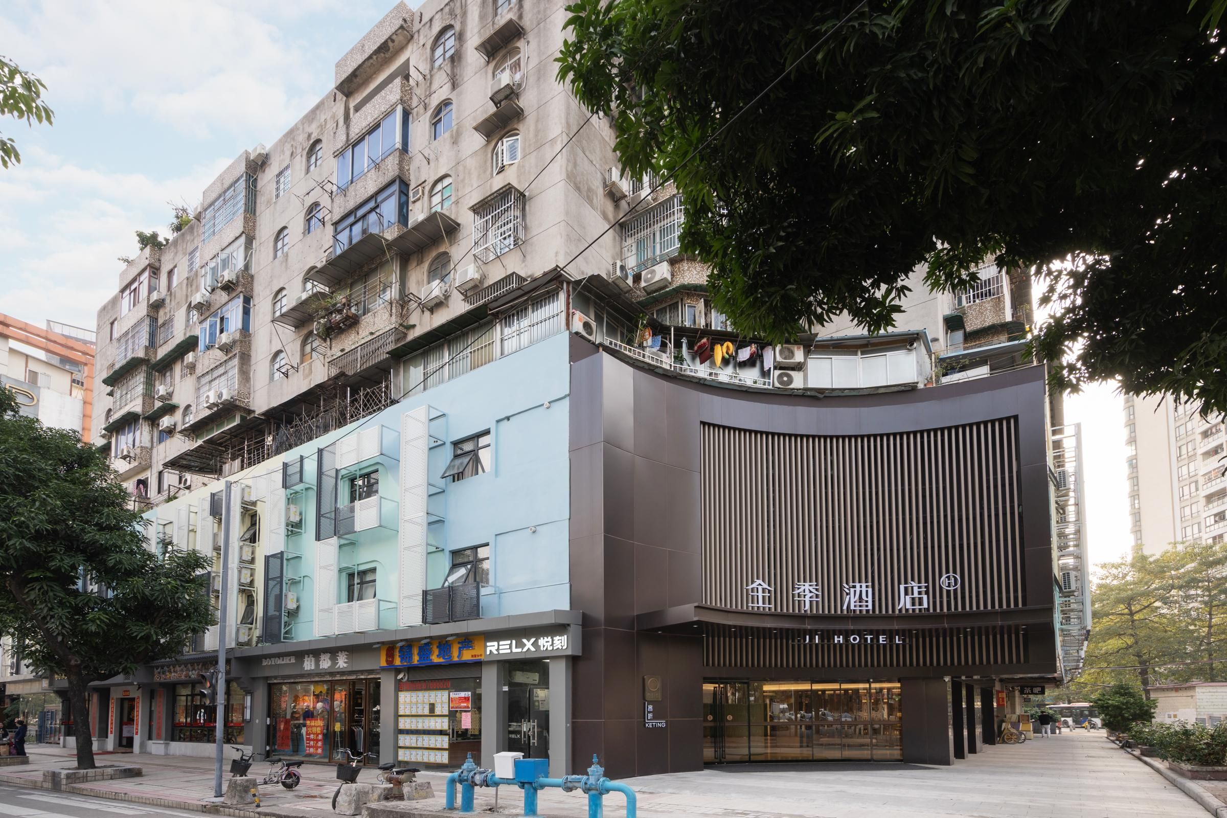 Un hôtel à l’architecture moderne, doté de nombreux balcons et abritant un restaurant visible depuis la rue, appelé « REILX », au rez-de-chaussée.