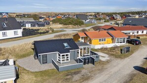 Zona residencial con casas, camino de grava y cielo despejado.