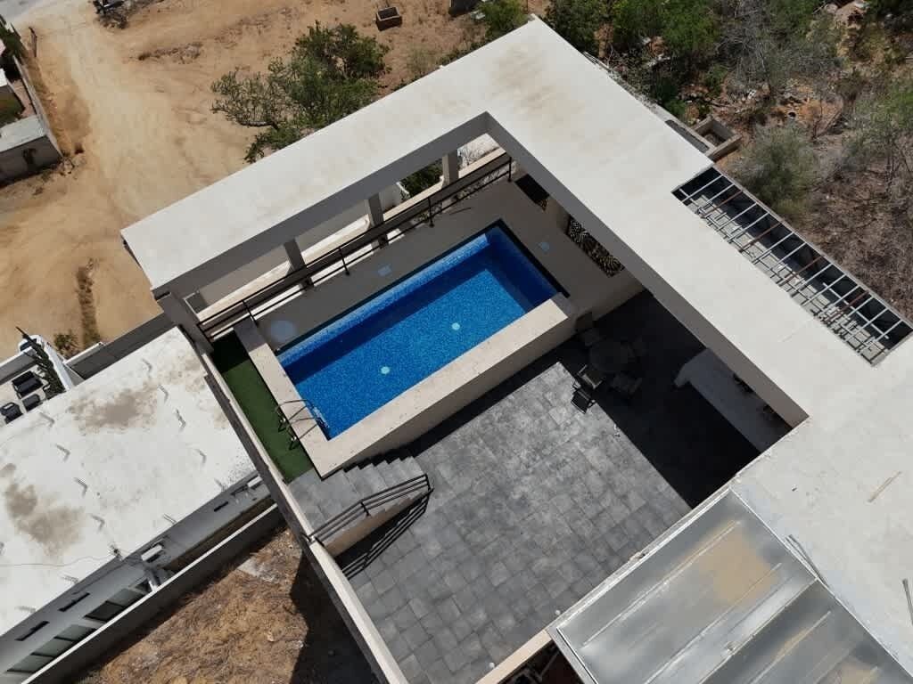 A modern building with a rooftop pool and a covered outdoor area.