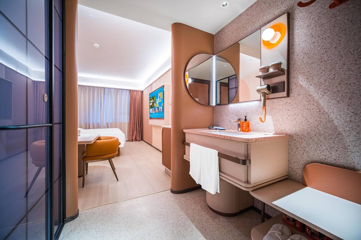 Ein modernes Hotelbad mit einem großen Spiegel, einem Waschbecken und einer Toilette.