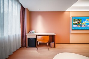 A hotel room with a desk, chair, and a television mounted on the wall. - Orange Hotel Guangzhou Yuexiu Park (Guangzhou)