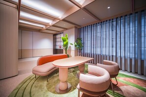 A modern hotel room with a large window, a dining table, and two sofas. - Orange Hotel Guangzhou Yuexiu Park (Guangzhou)