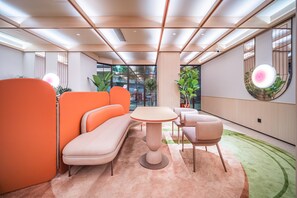 A modern lounge area with a sofa, chairs, and a table. - Orange Hotel Guangzhou Yuexiu Park (Guangzhou)