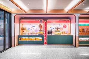 A brightly lit snack bar with two sections labeled "Low Fat Healthy" and "Coffee & Bread," featuring various food items and a coffee machine. - Orange Hotel Guangzhou Yuexiu Park (Guangzhou)
