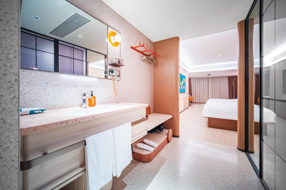 Ein modernes Hotelbad mit großem Spiegel, Waschbecken und Duschbereich.