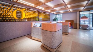 A modern reception area with a unique wall design, a digital information kiosk, and a spacious layout. - Orange Hotel Guangzhou Yuexiu Park (Guangzhou)